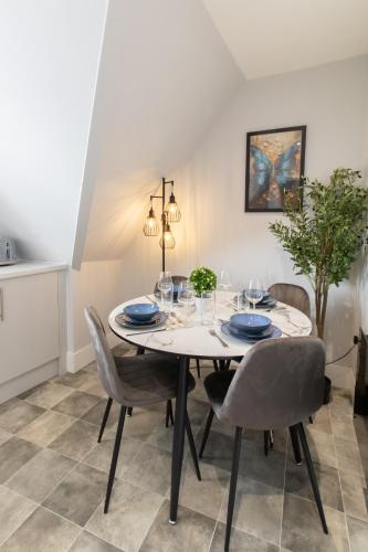 a dining room with a white table and chairs at Open Mind Property - Luxurious & Cosy Flat in Portsmouth