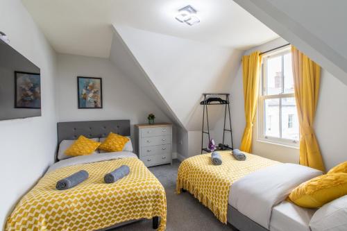 a attic bedroom with two beds and a window at Open Mind Property - Luxurious & Cosy Flat in Portsmouth