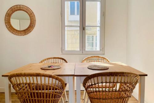 - une table à manger avec des chaises et un miroir dans l'établissement Le Grand Minage - Hypercentre Wifi, à La Rochelle