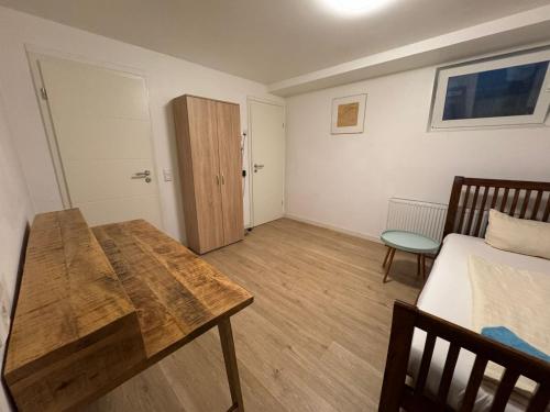 a bedroom with a bed and a wooden table in it at Business Apartment in Kaiserslautern
