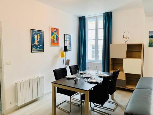 une salle à manger avec une table, des chaises et un canapé dans l'établissement Le Grand Cloutiers - Plein Centre Ville - Wifi, à La Rochelle