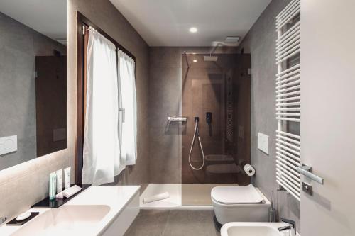 a bathroom with a shower and a toilet and a sink at Hotel Aquarius Venice - Ascend Collection in Venice
