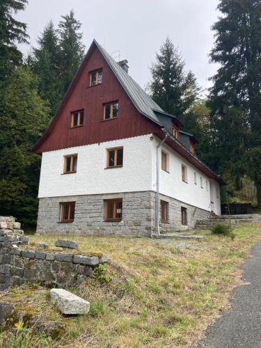 a large white barn with a red roof at chata Zuzka in Železná Ruda