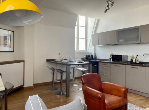 une cuisine avec une table et des chaises dans une pièce dans l'établissement L Echappee Rochelaise - Hypercentre Parking Prive, à La Rochelle