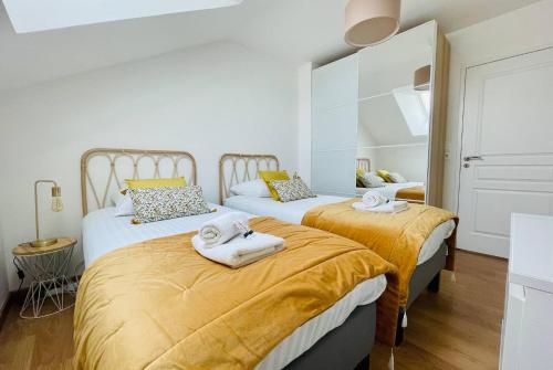 une chambre avec deux lits avec des serviettes dessus dans l'établissement L Echappee Rochelaise - Hypercentre Parking Prive, à La Rochelle