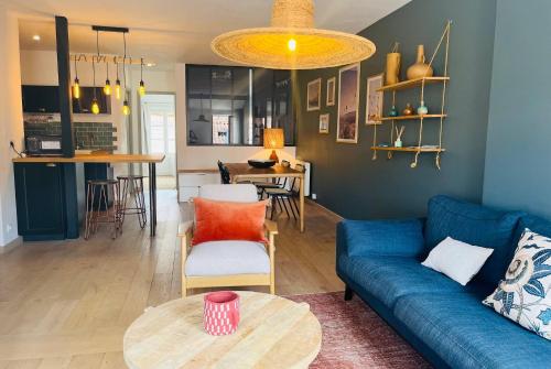un salon avec un canapé bleu et une table dans l'établissement Le Toit des Merciers - Hypercentre Wifi, à La Rochelle