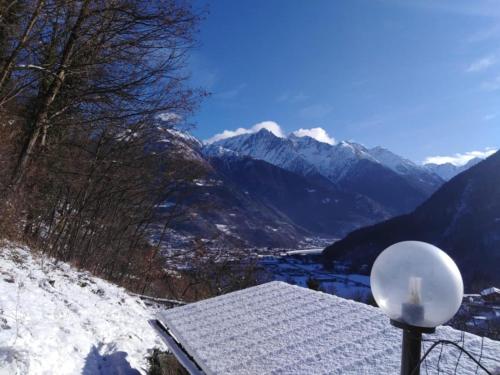 a view of a snowy mountain range with a house at Villa Amaranta Room and Breakfast in Edolo