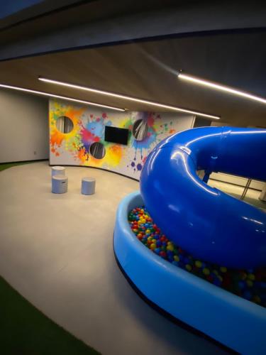 a play room with a blue slide and a painting at New time 1216 in Maceió