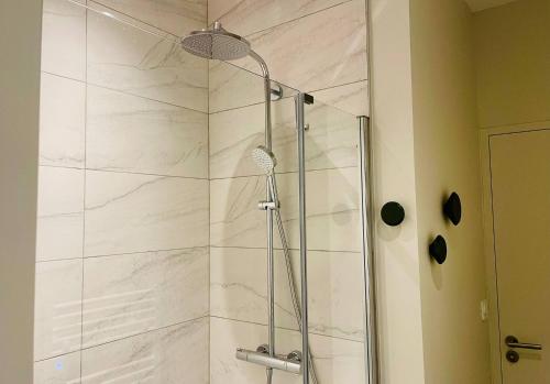 une douche avec une porte vitrée dans une salle de bain dans l'établissement Le Logis Gargoulleau, à La Rochelle