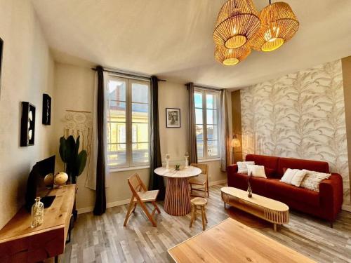 un salon avec un canapé rouge et une table dans l'établissement Le Petit Marche - T2 Hypercentre - Wifi, à La Rochelle