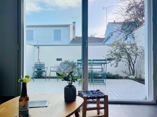 Elle offre une vue sur une terrasse dotée d'une table et d'une fenêtre. dans l'établissement La Petite Genette, à La Rochelle