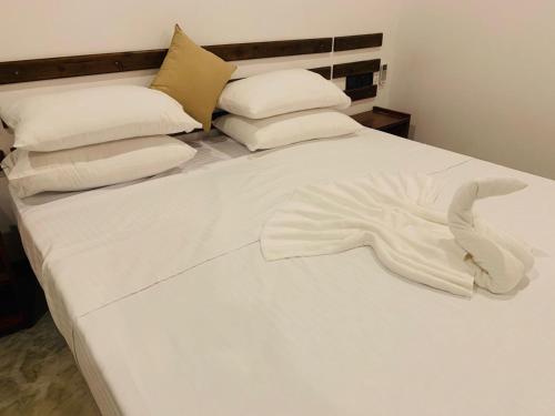 a white bed with white sheets and pillows at Wave Crest Villa in Dickwella