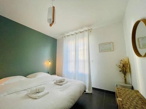 une chambre avec deux lits blancs et une fenêtre dans l'établissement La Petite Genette, à La Rochelle