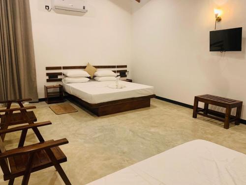 a bedroom with a bed and a flat screen tv at Wave Crest Villa in Dickwella