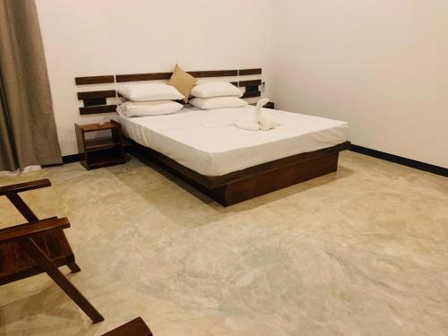 a bedroom with a bed with white sheets and pillows at Wave Crest Villa in Dickwella