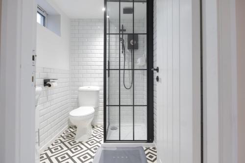 a bathroom with a toilet and a glass shower at Luxury Studio Apartment in Stoke on Trent