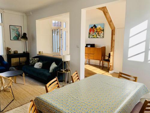 un salon avec une table et un canapé dans l'établissement Maison 3 chambres avec cour privative, à La Rochelle