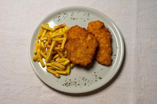 a plate of food with fried chicken and french fries at B&B Apartments Burić Plitvice Lakes in Plitvička Jezera