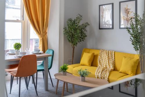 a living room with a yellow couch and a table at Open Mind Property - Cosy Flat in Southsea in Portsmouth
