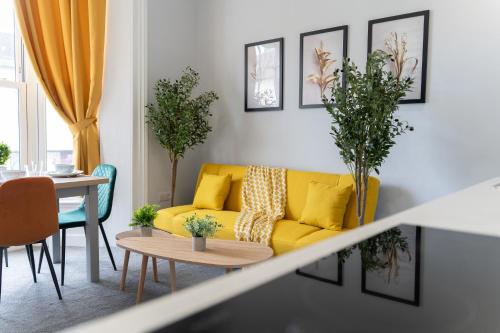 a living room with a yellow couch and a table at Open Mind Property - Cosy Flat in Southsea in Portsmouth