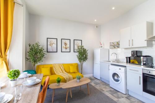 a living room with a yellow couch and a table at Open Mind Property - Cosy Flat in Southsea in Portsmouth