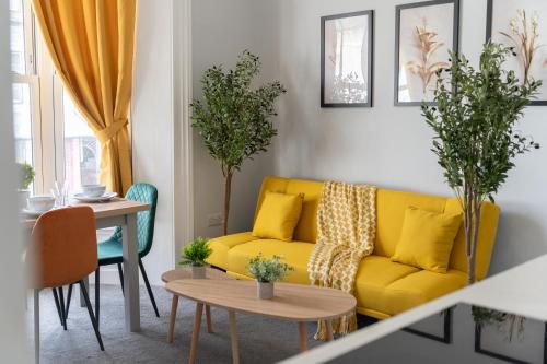 a living room with a yellow couch and a table at Open Mind Property - Cosy Flat in Southsea in Portsmouth