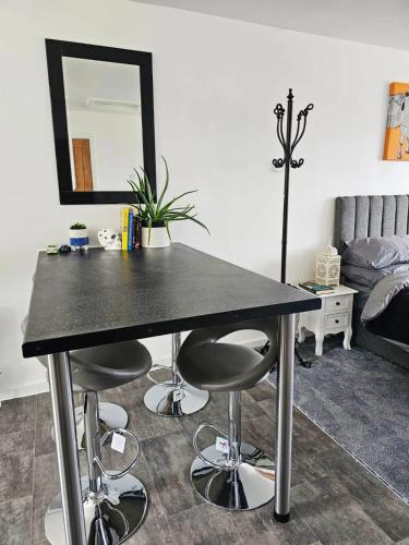 a table with two stools and a mirror in a room at Badger Haven, Apartment 4 in Brackley