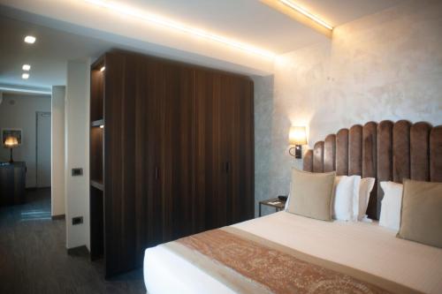 a bedroom with a large bed with a wooden headboard at Hotel Aquarius Venice - Ascend Collection in Venice