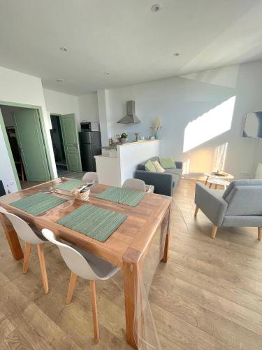 un salon avec une table et des chaises en bois dans l'établissement L'îlot vert, à Wimereux
