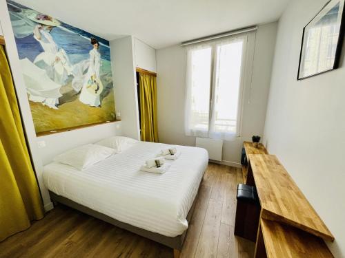 une chambre avec un lit et un tableau au mur dans l'établissement Appartement vue port - quai valin, à La Rochelle