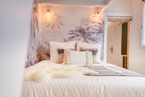 - une chambre avec un lit blanc et un papier peint tropical dans l'établissement 8 rue fleuriau avec cour privative, à La Rochelle