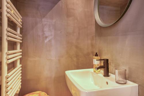 une salle de bain avec un lavabo et un miroir dans l'établissement 8 rue fleuriau avec cour privative, à La Rochelle