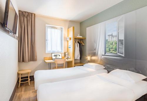 une chambre d'hôtel avec deux lits et un bureau dans l'établissement B&B HOTEL Tours Nord 2 La petite Arche, à Tours