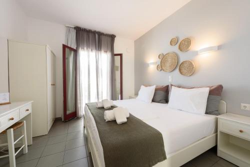 a bedroom with a large white bed with white pillows at Archipelagos Studios in Naousa