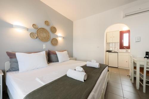 a bedroom with a large white bed and a kitchen at Archipelagos Studios in Naousa