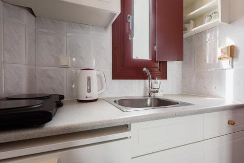 a kitchen counter with a sink and a appliance at Archipelagos Studios in Naousa