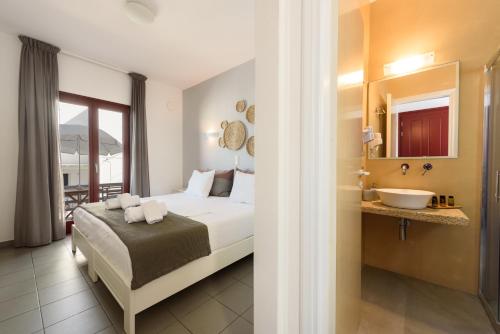 a hotel room with a bed and a sink at Archipelagos Studios in Naousa