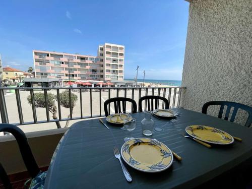 une table bleue avec des assiettes et de l'argenterie sur un balcon dans l'établissement Appartement 2 pièces cabine 6 couchages ST CYPRIEN PLAGE SC220-007, à Saint Cyprien Plage