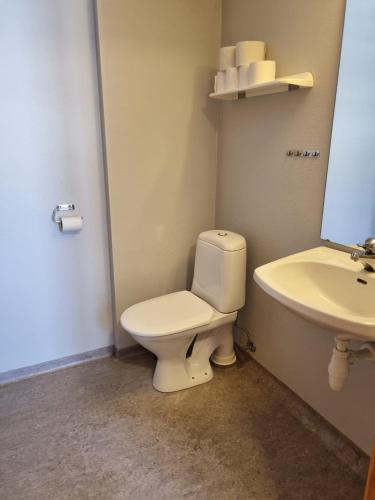 a bathroom with a toilet and a sink at Leilighet rett ved stranden in Mandal