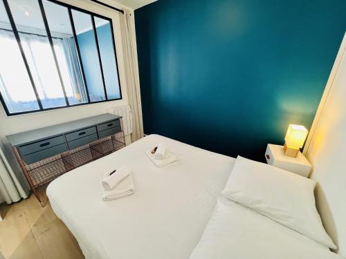 une chambre avec un lit blanc et une grande fenêtre dans l'établissement La Fonderie 1er etage - Centre Ville La Rochelle Wifi, à La Rochelle