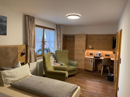 una camera da letto con un letto, due sedie e una scrivania di Hotel und Berggasthof Zum Sonnenhof a Sorge