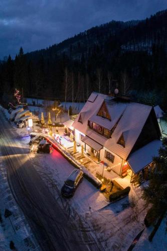 a building with cars parked in the snow at night at Villa Biesisko Przysłup Cisna in Cisna