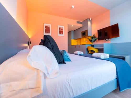 a bedroom with a large white bed with an orange wall at La marina sunset 3000 in Soto de la Marina