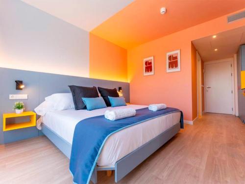 a large bed in a room with orange and blue at La marina sunset 3000 in Soto de la Marina