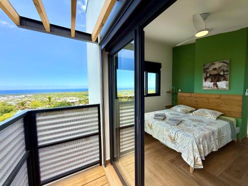una camera da letto con un letto con pareti verdi e un balcone di Vacoa - Villa Salba. Panoramic view. a Étang-Salé