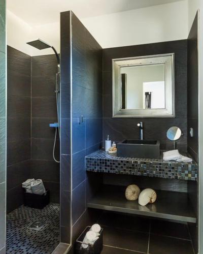 une salle de bain avec un lavabo et un miroir dans l'établissement Villa en pierre avec piscine chauffée, à proximité des plus belles plages du sud de la Corse !, à Figari