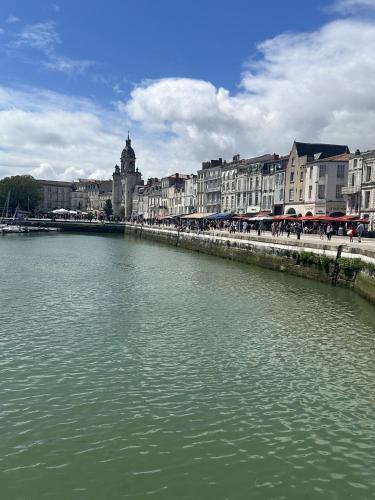 une rivière en face d'une ville avec des bâtiments dans l'établissement Coeur de ville - studio pour 2 personnes, à La Rochelle