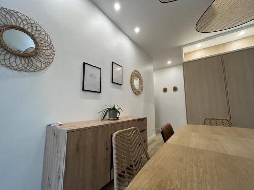 - une salle à manger avec une table et un miroir mural dans l'établissement Centre ville - t2 de standing, à La Rochelle