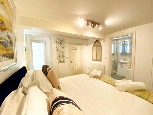 a large white bed in a room with a bathroom at No1 Marina Court - Wow Sea View Apartment in Torquay