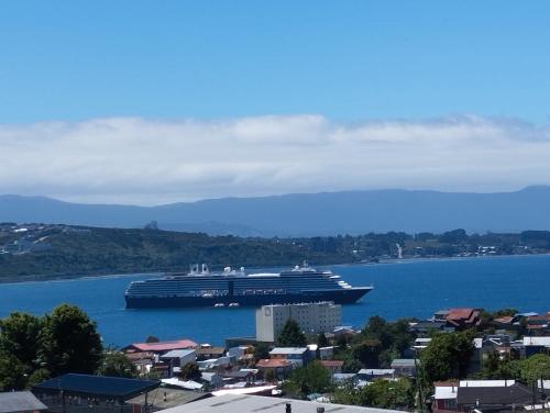 a large cruise ship in a large body of water at Cabañas Cristóbal in Puerto Montt